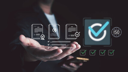 A man in a suit presents a hand holding a phone, with digital overlays of documents, checkboxes, a large checkmark, and an ISO symbol, symbolizing quality management and certification.