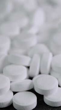 Vertical video sugar substitute pills rotating in macro. Artificial sweetener tablets zero calories