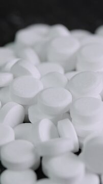 Vertical video sugar substitute pills rotating in close up. Artificial sweetener tablets zero calories