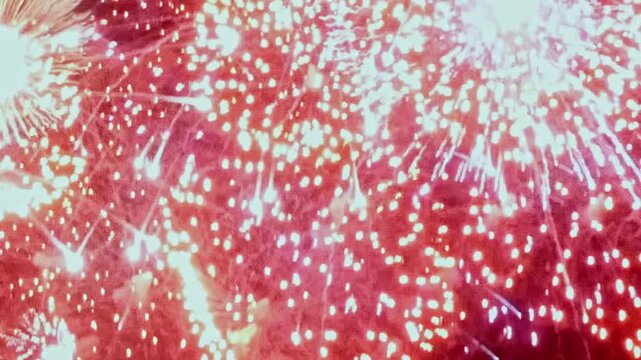 A radiant display of fireworks unfolds at night, casting a warm glow across the sky in an Eastern setting, creating a breathtaking moment of celebration.