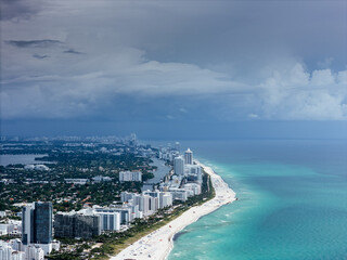 Aerial view of Miami waterfront houses with boats docked along a canal on a sunny day. g.