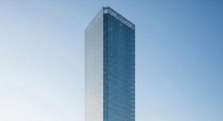 Obraz premium Sleek Modern Glass Skyscraper Against Blue Sky for Business and Urban Concepts