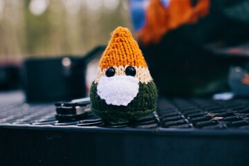 there is a small knitted gnome sitting on a table