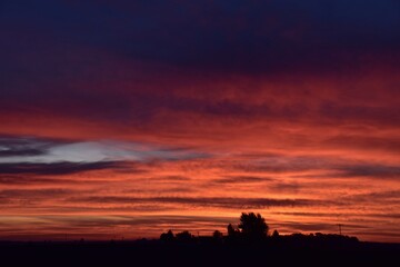 araffe sunset with a red sky and a few clouds