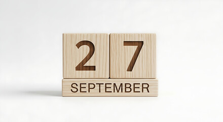 A clean, centered shot of a wooden block calendar displaying the date September 27.