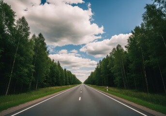 Long Empty Road Through Green Forest Under Blue Sky with White Clouds
