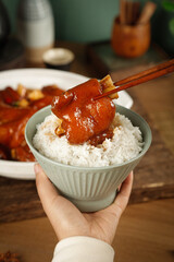 Delicious Glazed Pork Trotters Over Rice - Traditional Asian Cuisine with Chopsticks