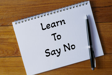 Learn to say no written in a notebook on wooden desk