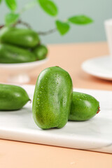 Fresh Mini Kiwi Berries with Water Droplets on White Cutting Board - Healthy Organic Fruit