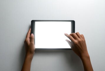 Dark-skinned hands gently manipulate a tablet with a bright white screen, set against a stark, neutral background, conveying a sense of modern interaction