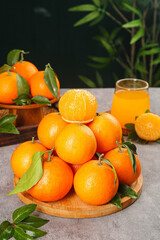 Fresh Organic Oranges with Leaves on Wooden Plate and Orange Juice Glass - Healthy Citrus Fruit Concept