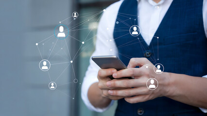Man uses smartphone connecting to global network of people icons, symbolizing digital communication and social media reach for modern business