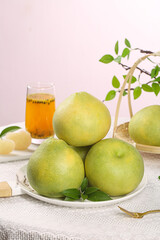 Fresh Green Pomelo Citrus Fruits on White Plate with Natural Sunlight and Tea Glass Healthy Organic Food Still Life