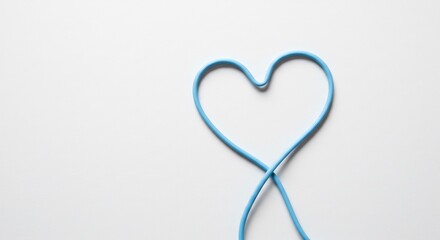 Soft light illuminates delicate blue cord forming heart shape. AI Generated