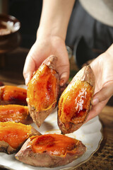 Fresh Roasted Sweet Potatoes with Honey Glaze Held in Hands - Traditional Baked Root Vegetable