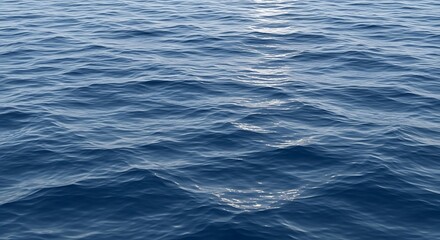 Naklejka premium Azure blue ocean surface with gentle ripples reflecting sunlight, a serene natural water background