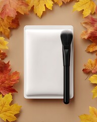 Autumn makeup flat lay with cosmetic brush and compact case.