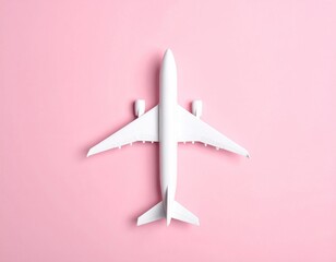 Overhead studio shot of a simple white airplane model isolated against a vibrant pink background, minimal composition and soft lighting