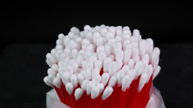 Cotton swabs rotating, cotton buds close up shot on black background. Personal hygiene and cosmetic items. Ear cleaning q tips