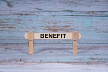 Benefit symbol. Single Wooden stick squeezed by Clothespins, Grungy blue Wooden Texture Background....