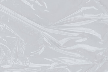 Crinkled clear plastic wrap on bright surface. Suitable for ecofriendly packaging concepts, minimalistic design illustrations, and textures for digital projects.