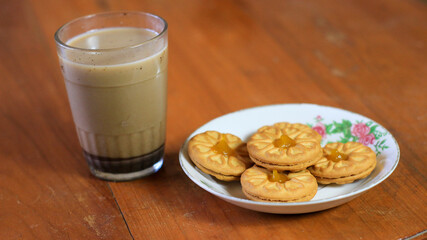 Breakfast and snack menu. Butter biscuits with pineapple jam and a glass of chocolate milk. Close-up of butter cookies and a glass of chocolate, sweet cakes. Perfect for recipes, articles, catalogs.