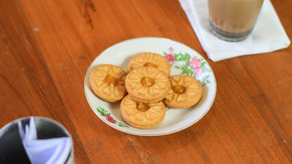 Breakfast and snack menu. Butter biscuits with pineapple jam and a glass of chocolate milk. Close-up of butter cookies and a glass of chocolate, sweet cakes. Perfect for recipes, articles, catalogs.