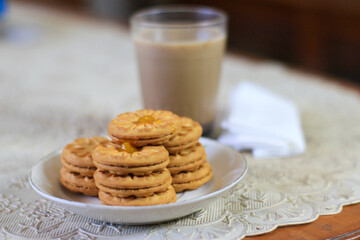 Breakfast and snack menu. Butter biscuits with pineapple jam and a glass of chocolate milk. Close-up of butter cookies and a glass of chocolate, sweet cakes. Perfect for recipes, articles, catalogs.