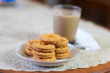 Breakfast and snack menu. Butter biscuits with pineapple jam and a glass of chocolate milk. Close-up of butter cookies and a glass of chocolate, sweet cakes. Perfect for recipes, articles, catalogs.