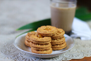 Breakfast and snack menu. Butter biscuits with pineapple jam and a glass of chocolate milk. Close-up of butter cookies and a glass of chocolate, sweet cakes. Perfect for recipes, articles, catalogs.