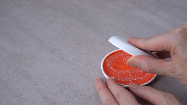 Opening Orange Dental Aligner Case that orthodontic mouthpiece storaged. Slow motion video.
