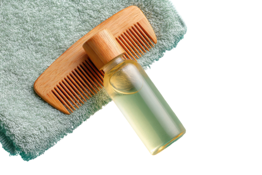 Light-green towel draped over, with wooden comb and small amber bottle of hair oil