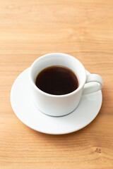 コーヒーカップに入ったコーヒー　木目背景