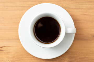 コーヒーカップに入ったコーヒー　木目背景