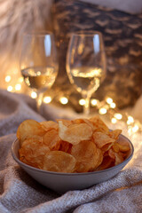 Crispy Chips with white Wine in a Cozy Setting on a Table.