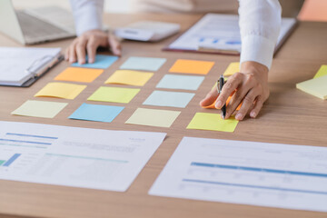 Business People working on sticky notes creative writing down ideas on post it notes professional...