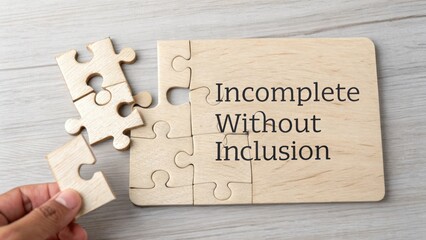 Incomplete Without Inclusion Message on Wooden Puzzle Piece with Hand Holding Missing Piece for Symbolism