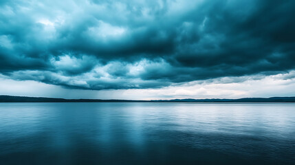 Obraz premium Serene lake reflects dark clouds, creating dramatic scene under moody weather conditions. tranquil water contrasts with stormy sky