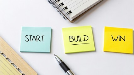 Motivational Sticky Notes for Business Success: Start Build Win with Notepad and Pen on Clean Desktop Surface