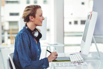 Creative businesswoman using graphic tablet and computer in modern office