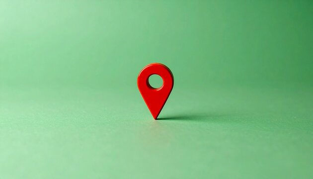 Red map pin on green surface, symbol of location and navigation.