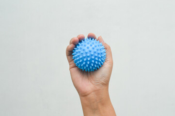 Massage and health therapy through the palms of the hands with blue spiked balls on a white background