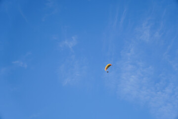 Paragliding on a sunny day with cirrus clouds, enjoying freedom and adventure