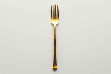 A gold-colored fork positioned centrally on a plain white background.