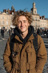 Smiling young man in casual winter attire near historic building