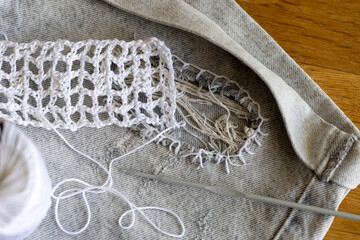 Process of creatively repair jeans shorts with crocheting patch on hole, customizing and upcycling clothes