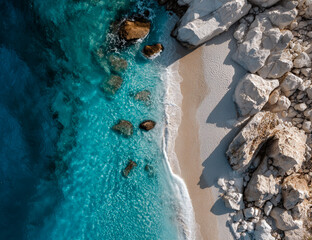 Aerial view of a serene beach with turquoise water and rocky shoreline