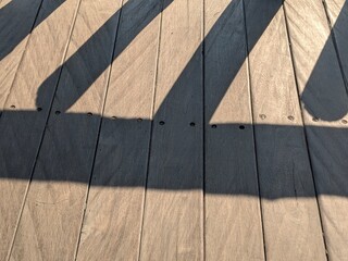 Dark paint stripes on light wood deck, showing partially completed project.
