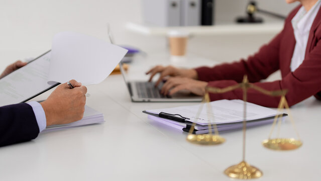 Adult professionals collaborate legal documents at modern office Lawyers consult business contract details using laptop paperwork justice fairness