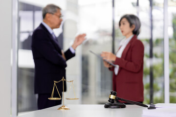 Legal professionals discuss law matters in modern office setting with justice scales and gavel symbolizing legal expertise and consultation